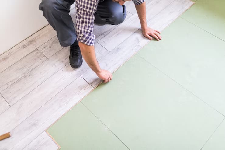 Installer laying bright laminate flooring boards