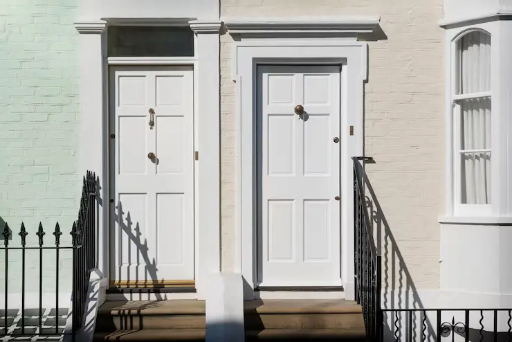 Front view of modern front doors with green and beige wall