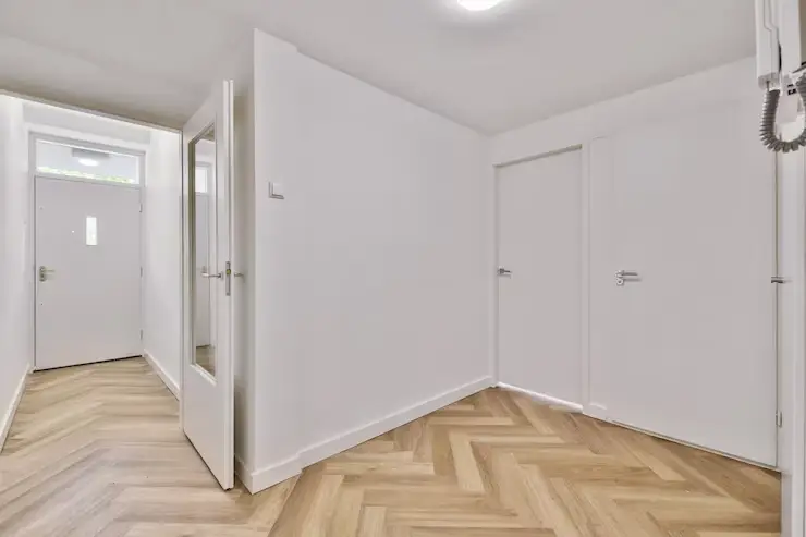 Empty interior area with white walls and laminate flooring