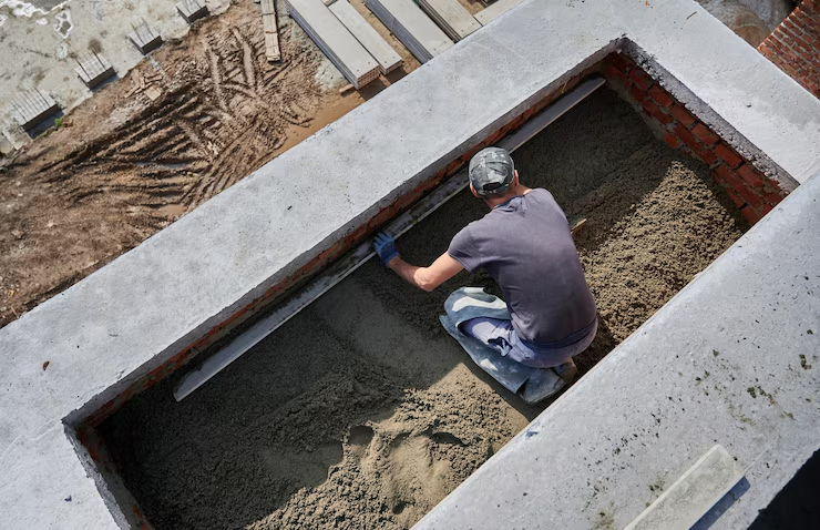 Worker screeding floor at construction site